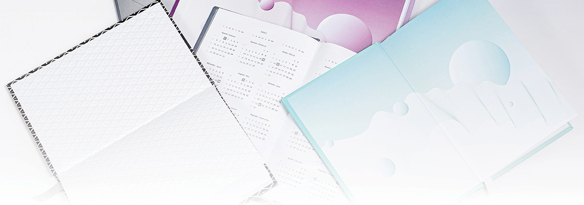 Nofotografuotos kelios atverstos darbo knygos, jų prie&scaron;lapiuose pavaizduoti grafiniai elementai ir kalendorius.